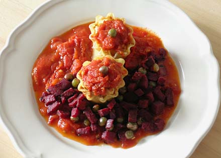 Lasagna rolls in tomato sauce with sautÃ©ed onion, beetroot and peas as topping