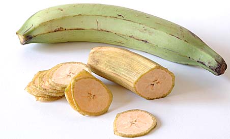 Plantain with outer skin peeled and sliced into thin round chips and whole Plantain